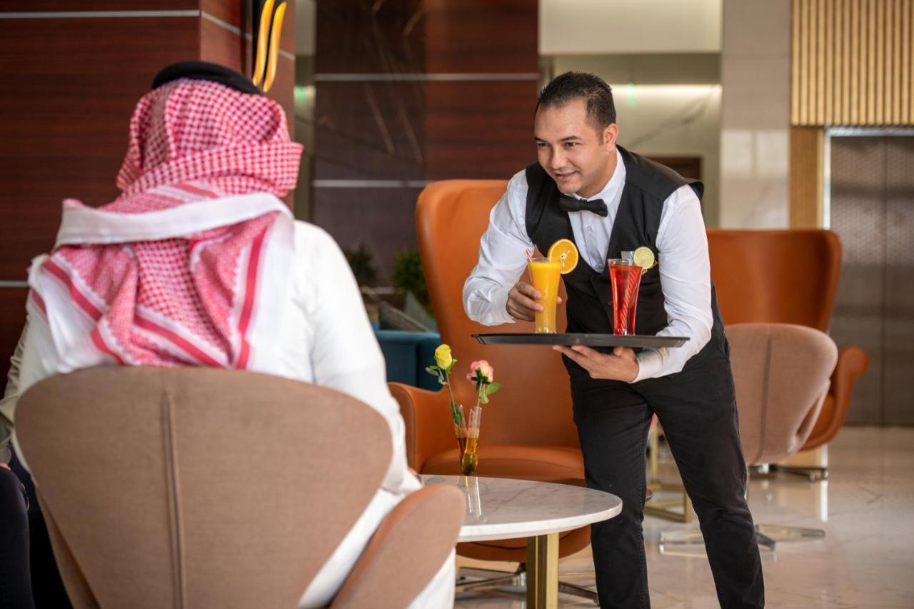 Nivel Hotel Abha Khamis Mushait Eksteriør billede A waiter serving drinks